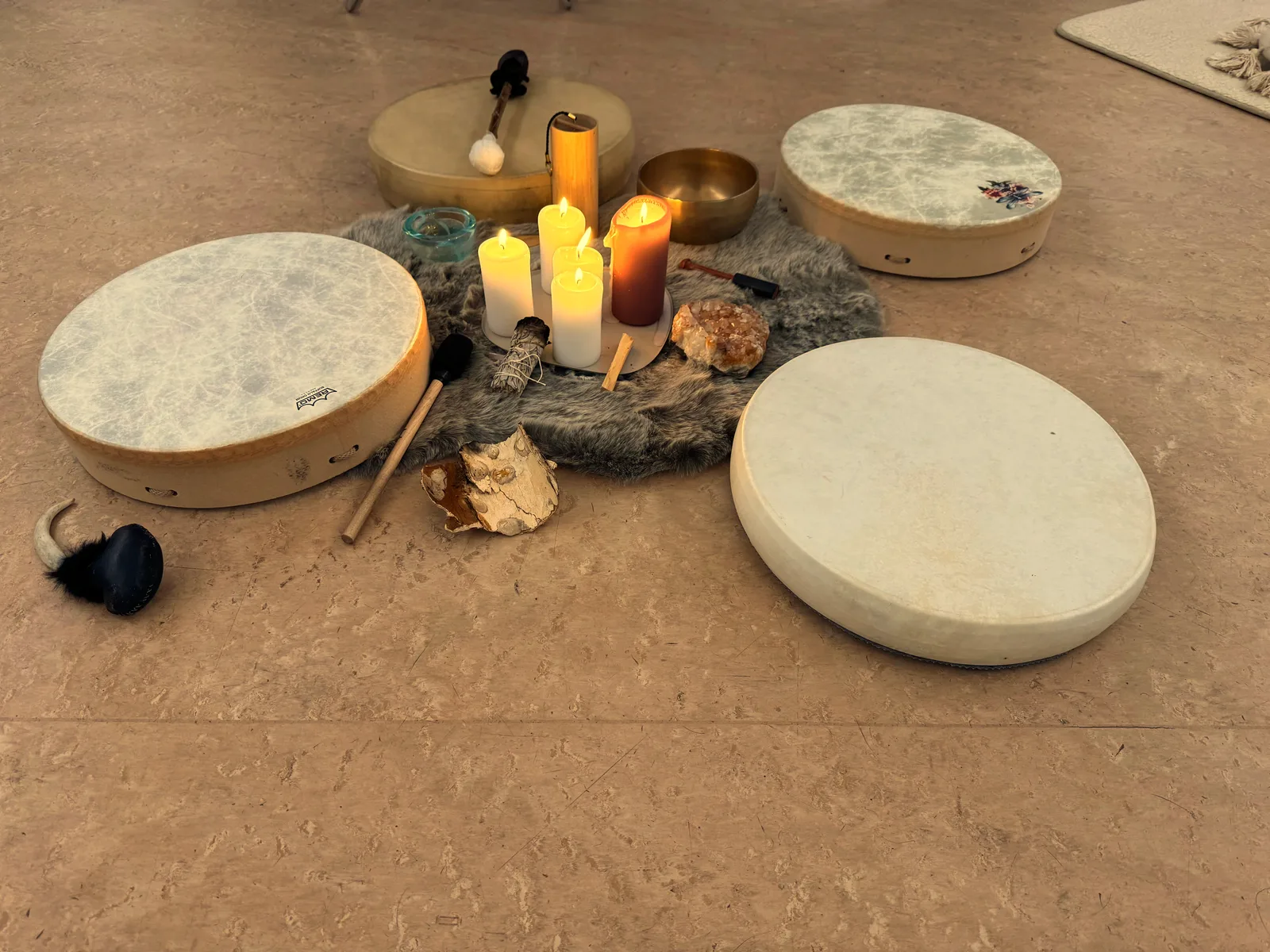 Shamanic drum circle setup with drums, candles and crystals